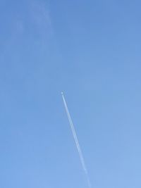 Low angle view of vapor trail against blue sky