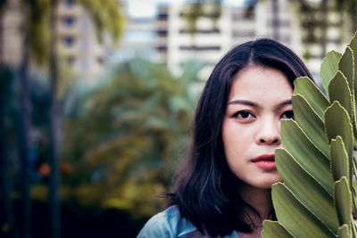 Portrait of young woman by leaves