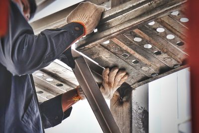 Low angle view of man working on metal 