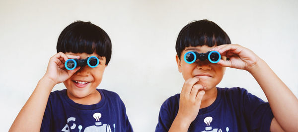 Multiple exposure, a boy and blue binoculars on a white background