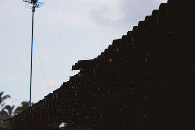 Low angle view of wet street light against sky