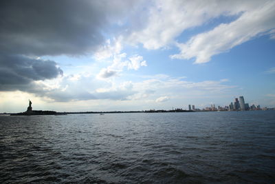 Scenic view of sea by buildings against sky