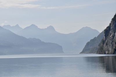 Scenic view of sea and mountains against sky