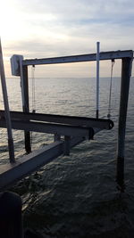 Pier over sea against sky during sunset