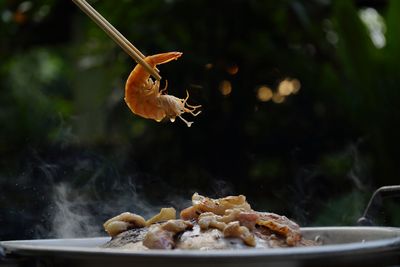 Thailand style bbq grill on a charcoal fire that is located on the bottom with pork, shrimp, squid 