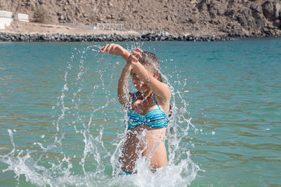Man splashing water in swimming pool