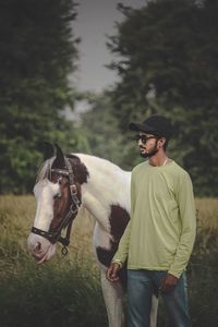 Rear view of man riding horse on field