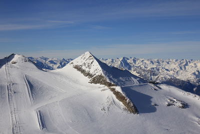 Scenic view of snowcapped mountains against blue sky