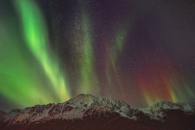 Scenic view of snowcapped mountain against sky at night