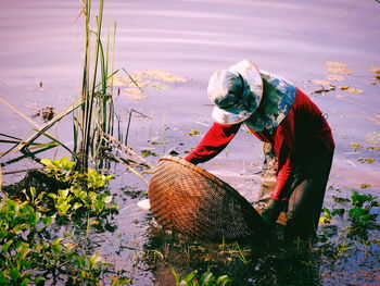 Side view of man working in basket