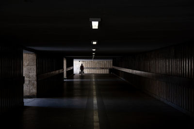 Man walking in illuminated tunnel