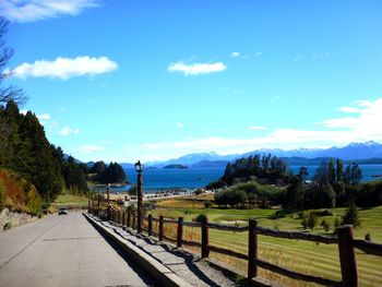 Road leading towards mountains against sky
