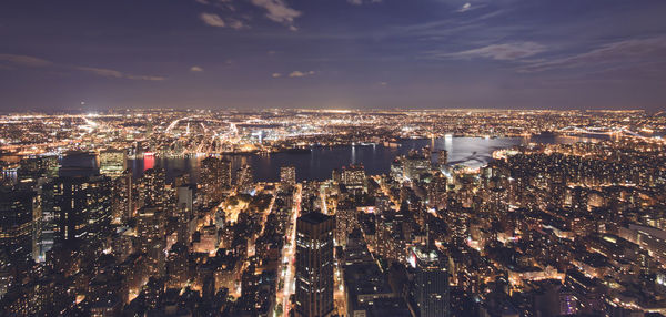 Aerial view of illuminated cityscape against sky at night