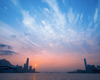 View of city buildings against cloudy sky