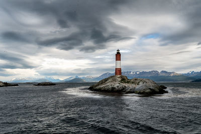 Lighthouse by sea against sky