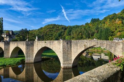 Arch bridge over river against sky