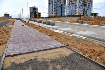 Road by building against sky in city