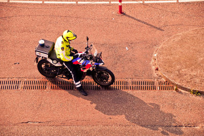 High angle view of man with motorcycle sitting on road