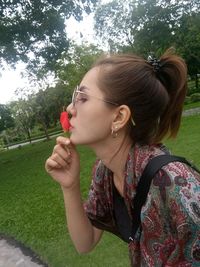 Side view of a young woman holding plant