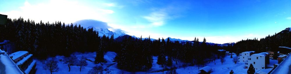 Panoramic view of ski lift against sky during winter