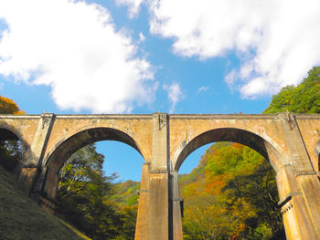 Low angle view of arch bridge against sky