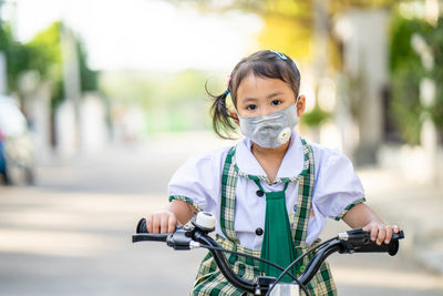 Portrait of girl with bicycle on street