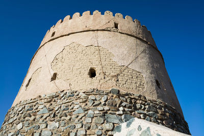 Low angle view of historic building against clear blue sky