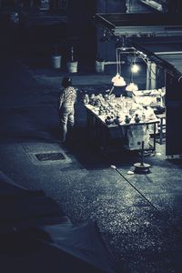 Rear view of people working on street at night