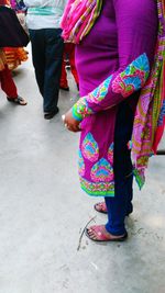 Low section of women standing on multi colored umbrella