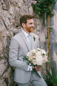 Midsection of bride holding bouquet