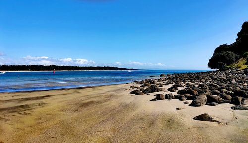 Scenic view of beach against blue sky