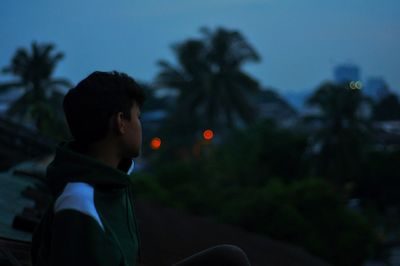 Side view of young man at dusk