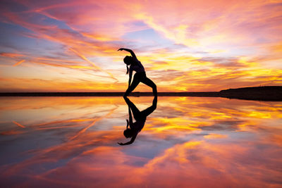 Silhouette person on sea against sky during sunset