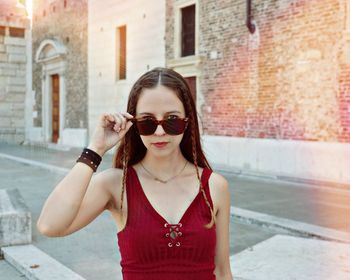 Portrait of young woman wearing sunglasses standing outdoors