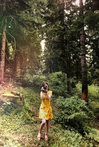 Woman photoshooting by canon in forest