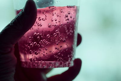 Cropped hand holding drink in glass