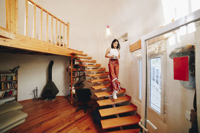 Mature woman moving down stairs at home