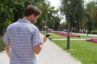 Rear view of man using mobile phone