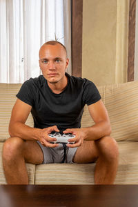 Portrait of man sitting on sofa at home