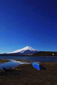 Scenic view of snowcapped mountain against blue sky