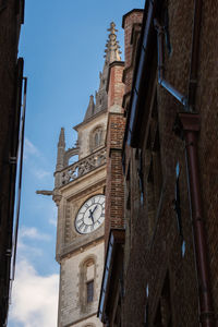 Low angle view of clock tower amidst buildings in city