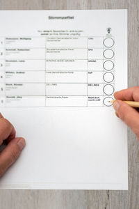 Cropped image of person holding paper