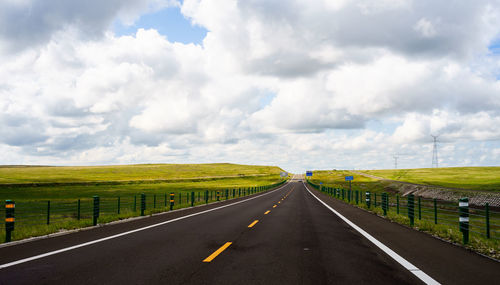 Empty road along countryside landscape