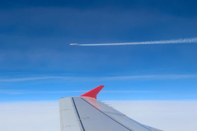 Cropped image of airplane flying against blue sky