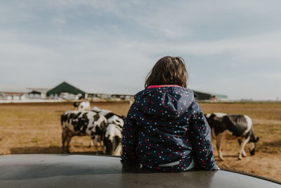 Rear view child looking at cows