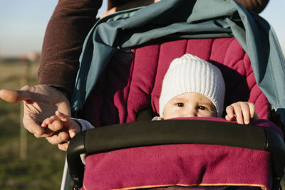 Midsection of father pushing baby in stroller