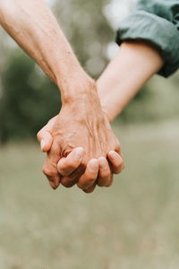 Happy senior couple holding hands. hands of man and woman hold each other. romance and love