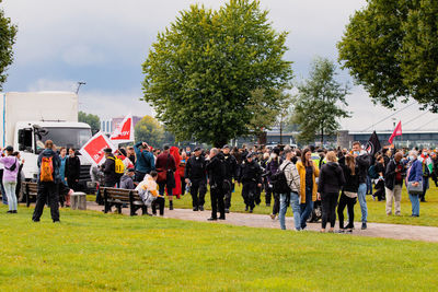 Group of people on field against trees in city