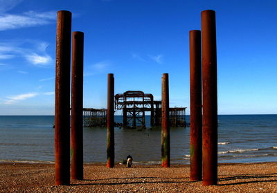 Pier on beach against sky