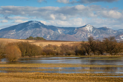 Scenic view of lake and mountains against sky